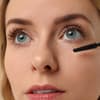 Frau tuscht Wimpern