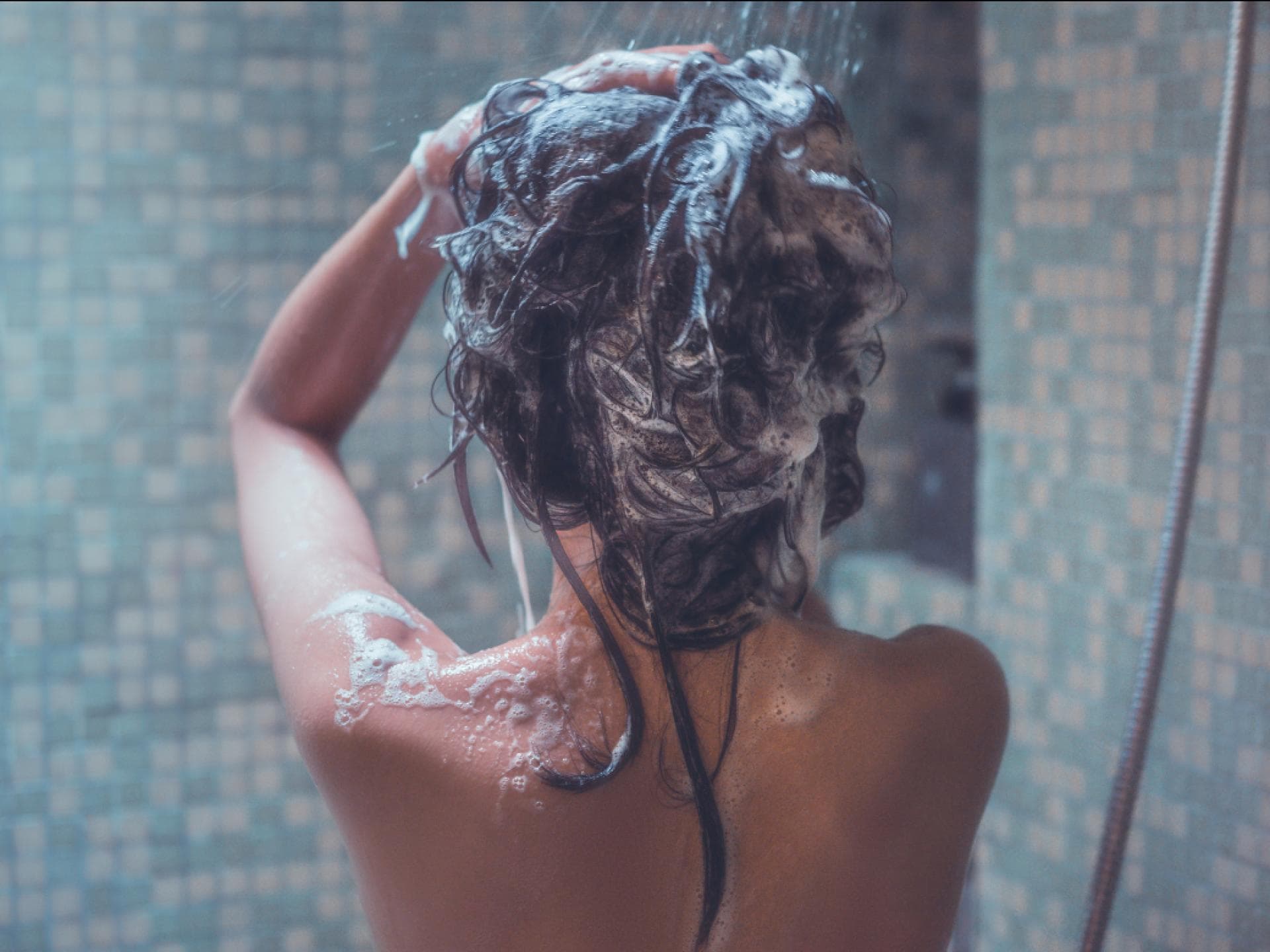 Shampoo mit Panthenol Frau wäscht Haare unter der Dusche